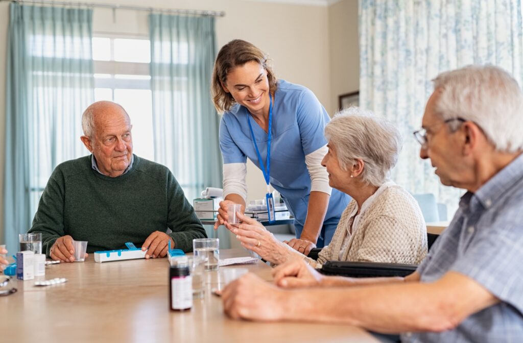 A caregiver at a memory care community helping some residents with their daily medications