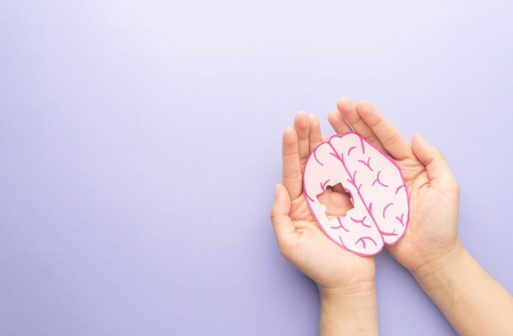 a hand holding a model of a brain with a puzzle piece missing symbolizing dementia