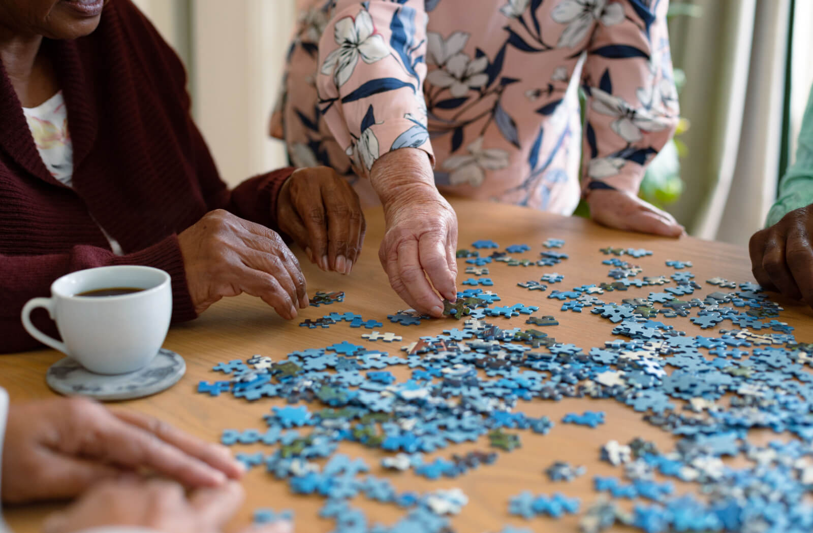 Two older adults working together on a jigsaw puzzle.
