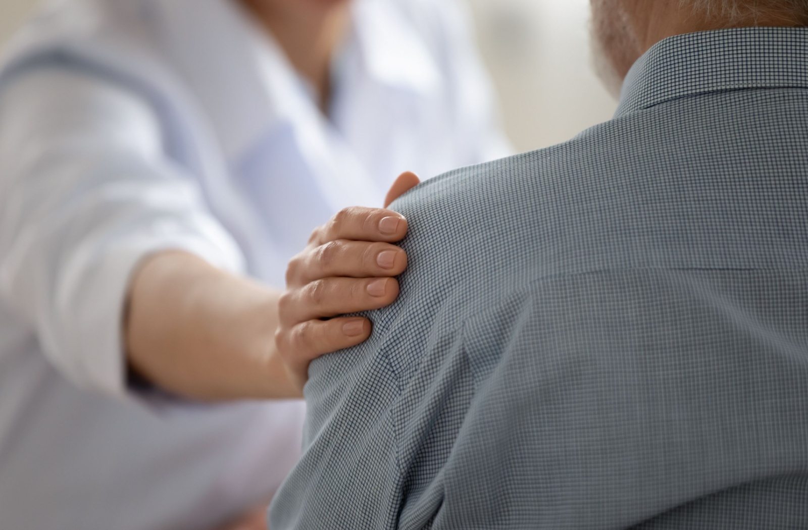 A caregiver reassuring a frustrated older adult with dementia during a conversation.