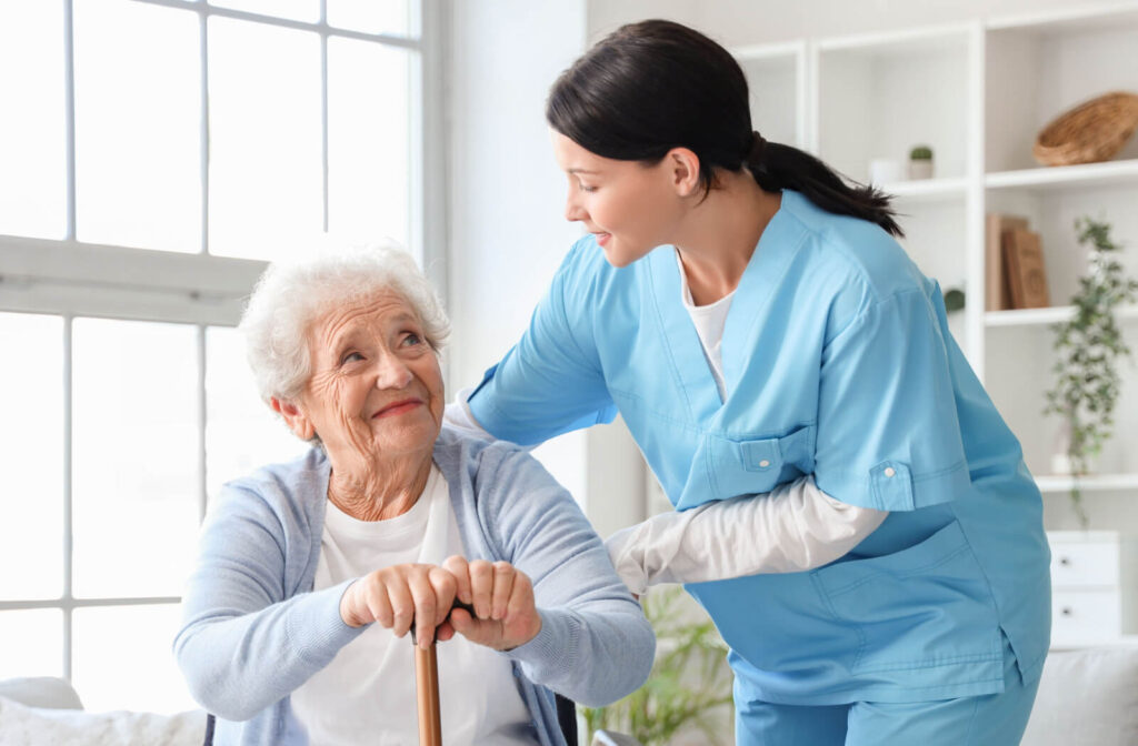 A caregiver smiles while checking on an appreciative resident in their home in memory care