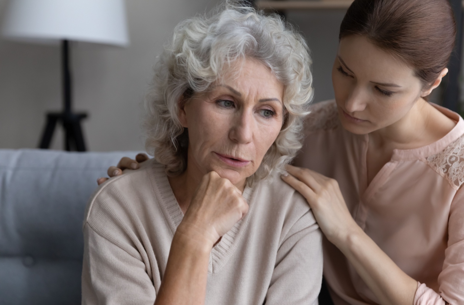 An adult child checks in on their older parent during a conversation about memory care